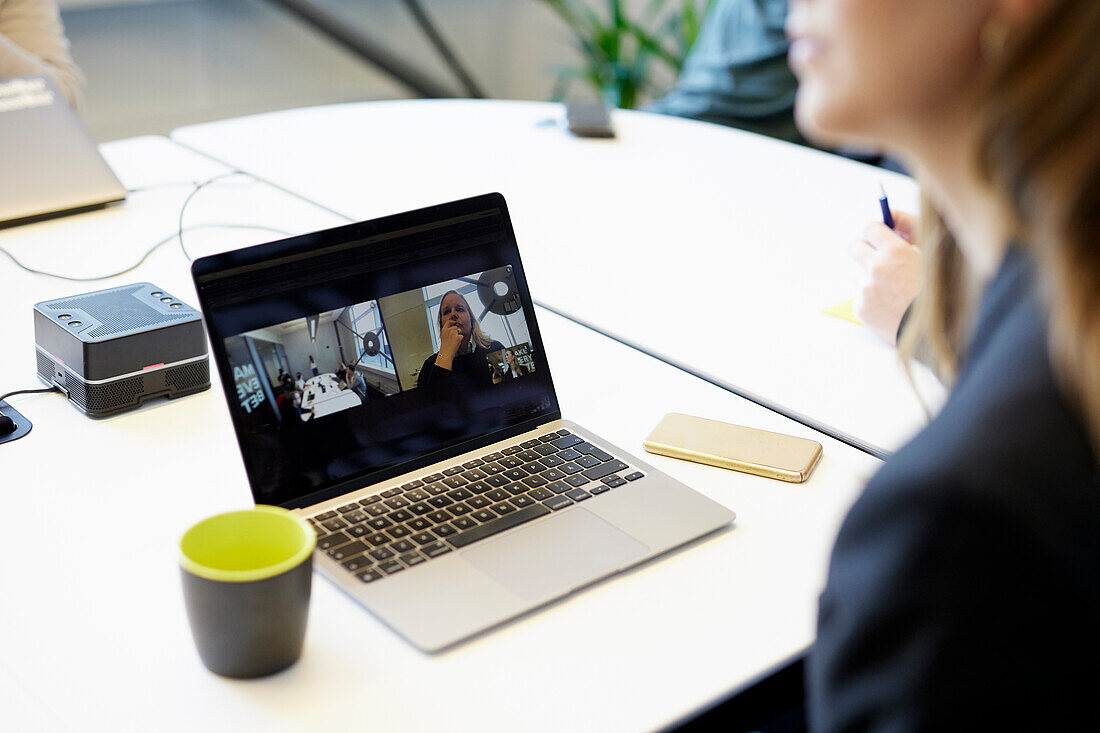 Laptop with video call on meeting table