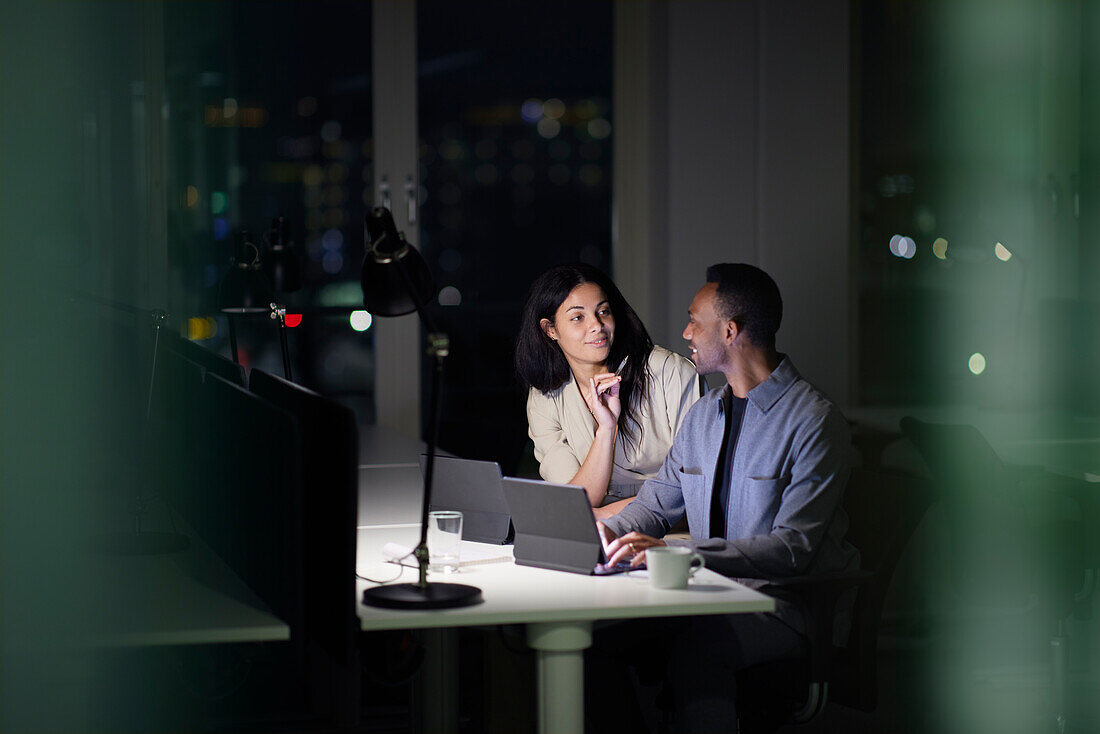 Man and woman working late in office