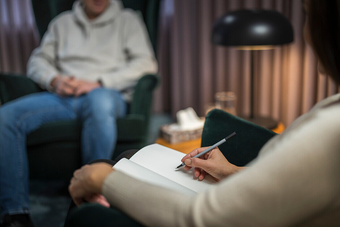 Ärztin macht Notizen in einer Therapiesitzung