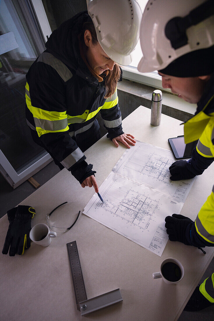 Engineers checking plans at building site