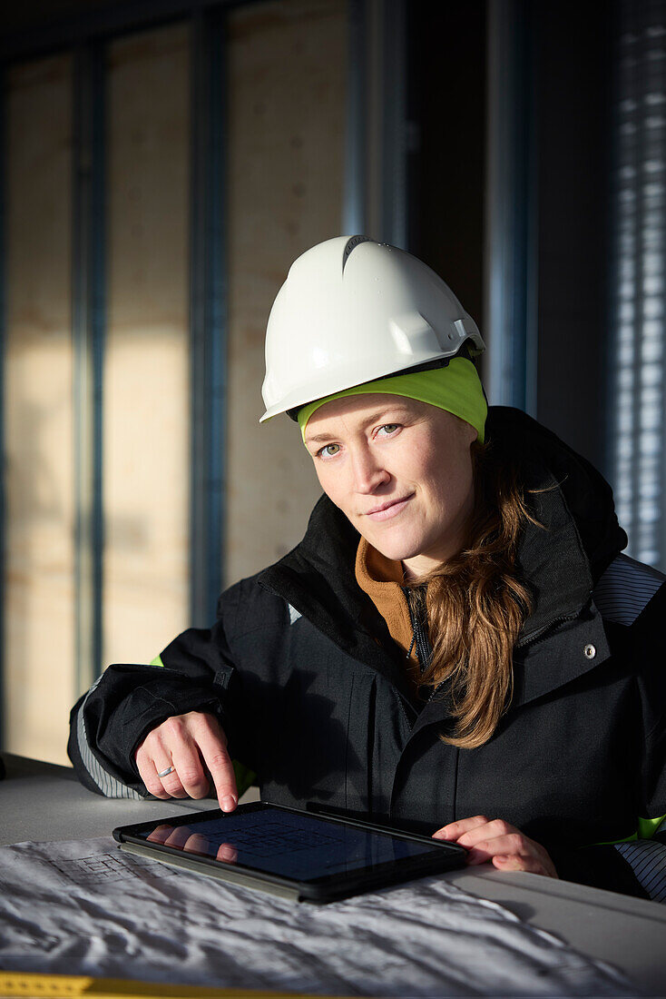 Female engineer checking plans on digital tablet