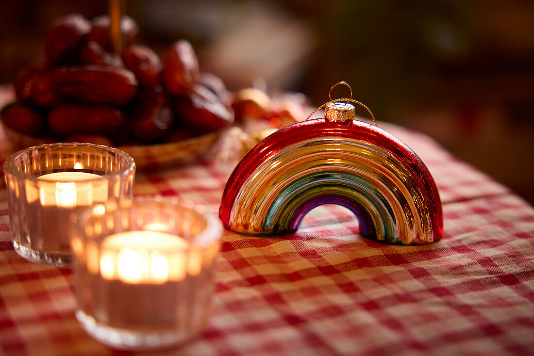 Regenbogen-Weihnachtskugel und Kerzen