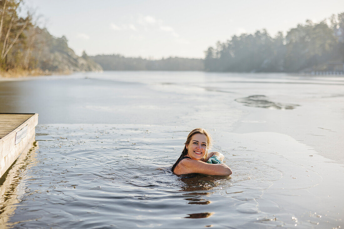 Woman swimming in lake at winter