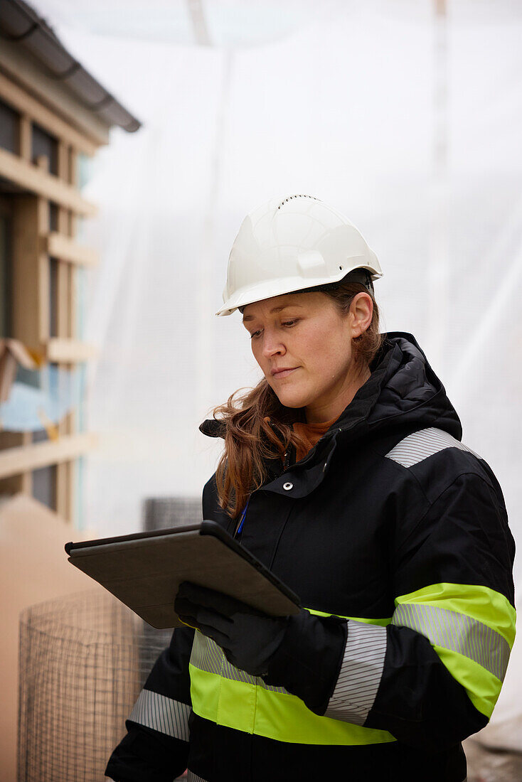 Female engineer using digital tablet at building site