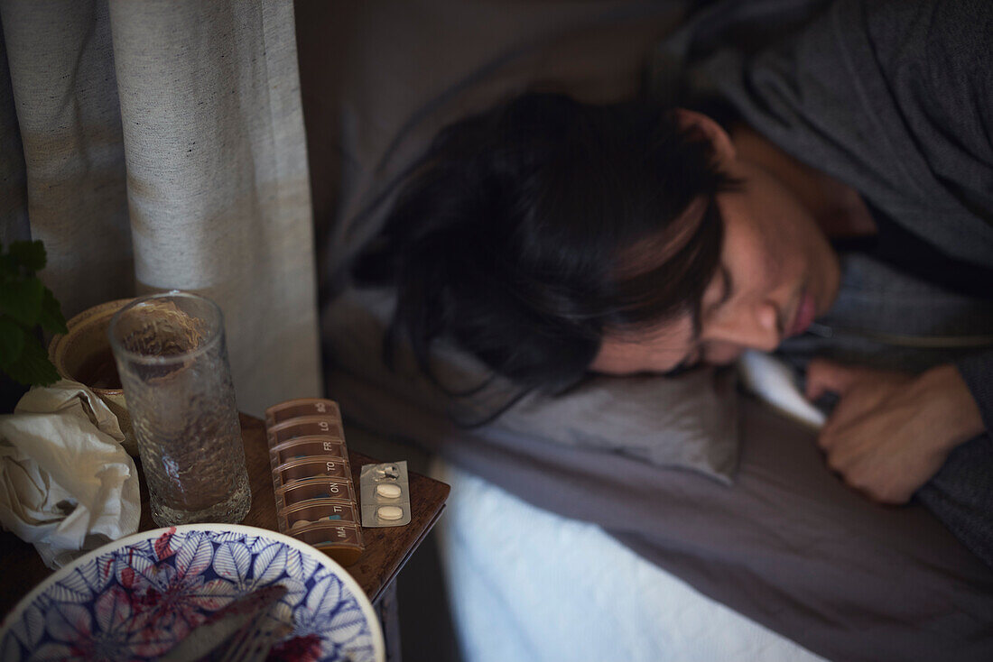 Sad man facing depression sleeping in bed