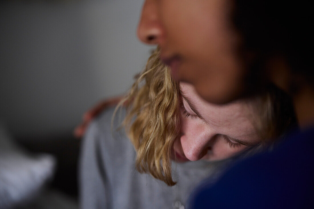 Young woman comforting crying friend