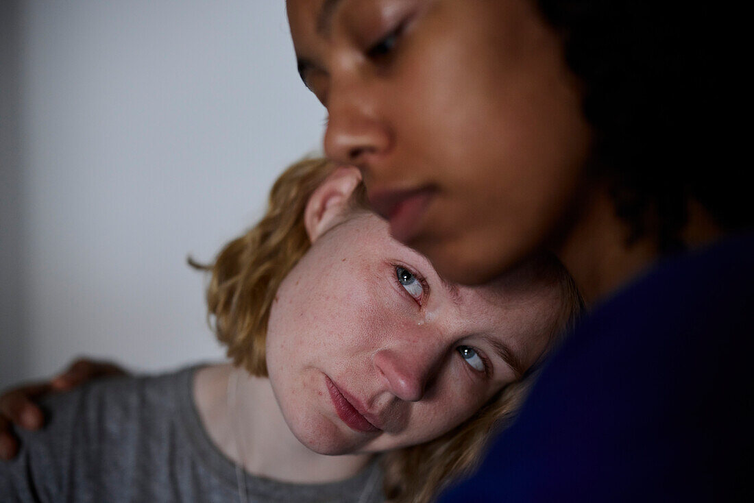 Young woman comforting crying friend