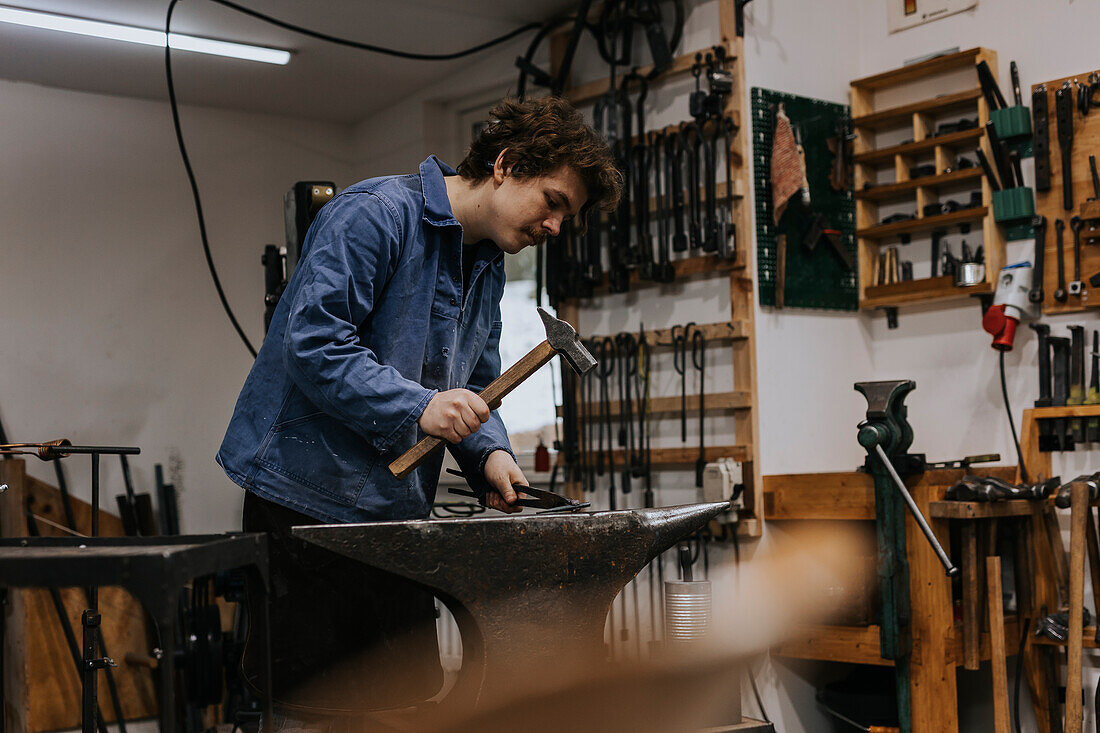 Schmied mit Hammer und Amboss in der Werkstatt