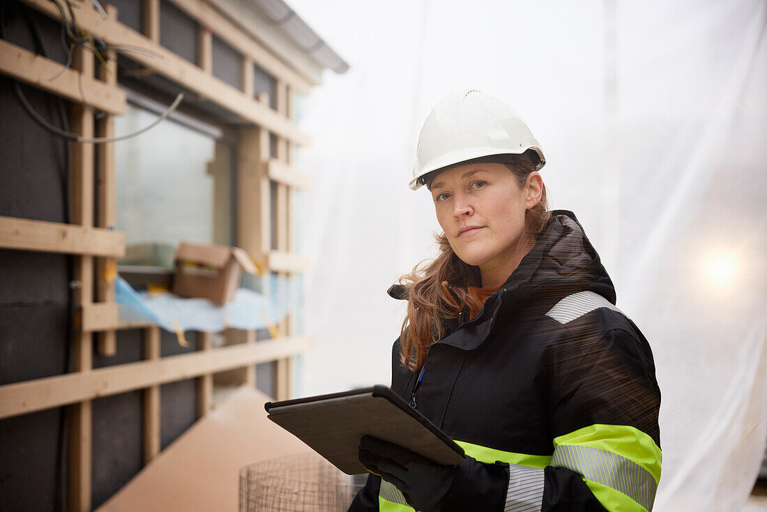 Ingenieurin mit digitalem Tablet auf der Baustelle