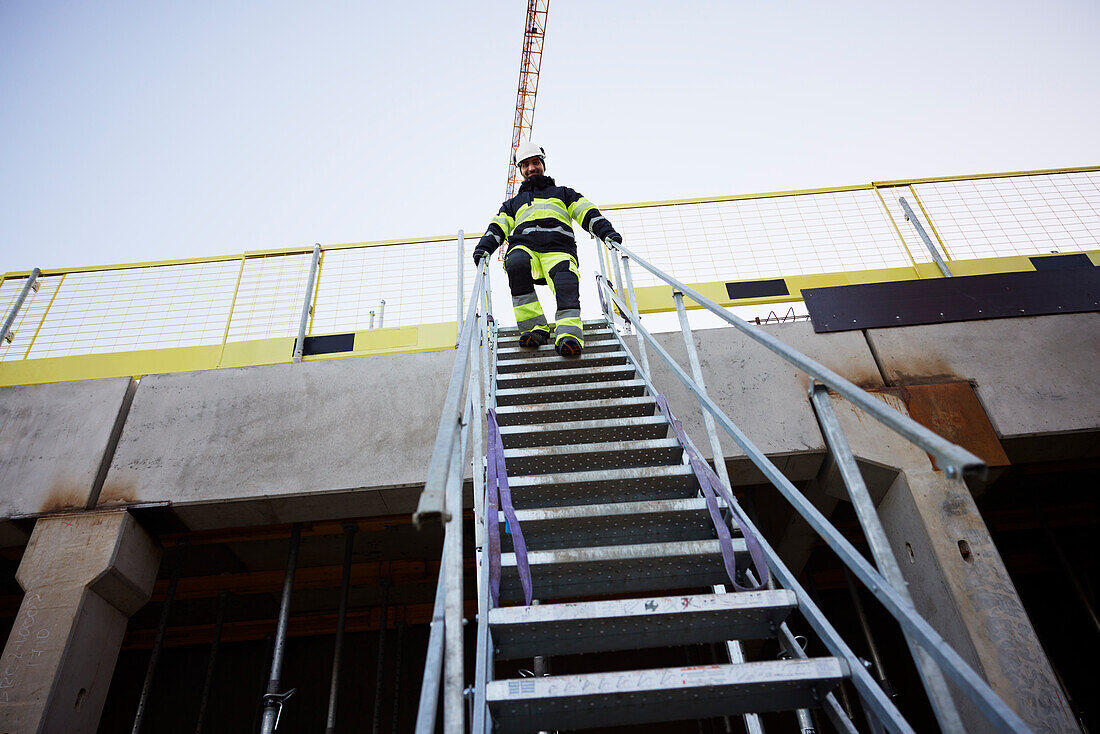 Engineer walking down stairs at construction site