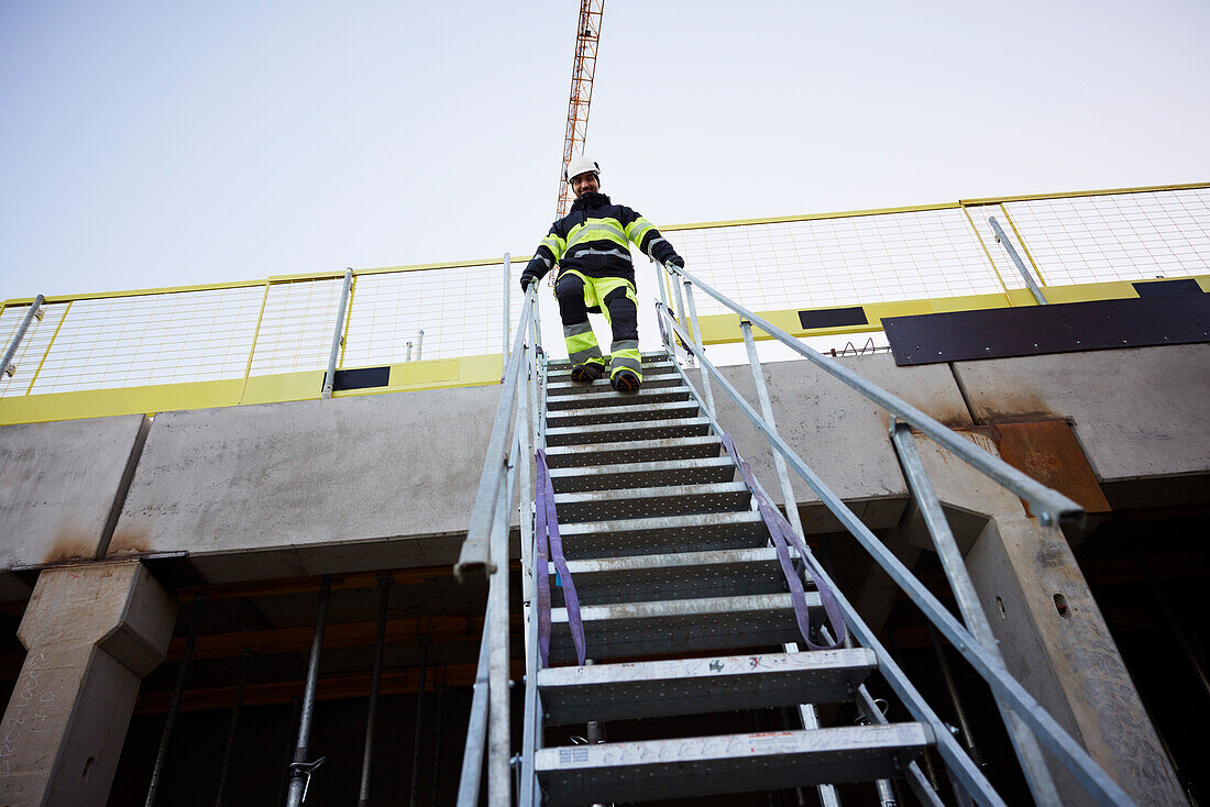 Ingenieur geht auf der Baustelle eine Treppe hinunter
