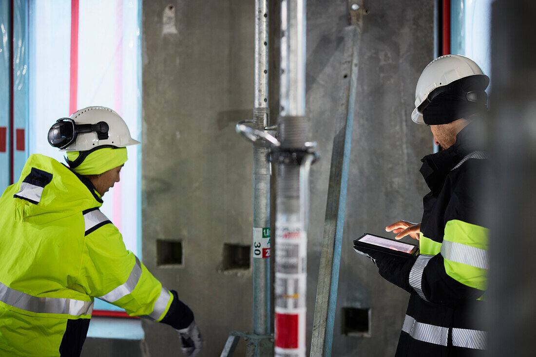 Male and female engineer working at construction site