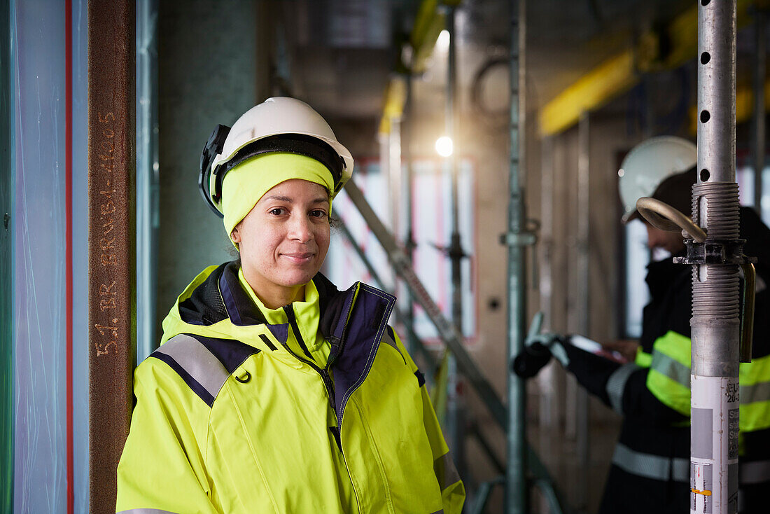 Porträt einer lächelnden Ingenieurin auf der Baustelle