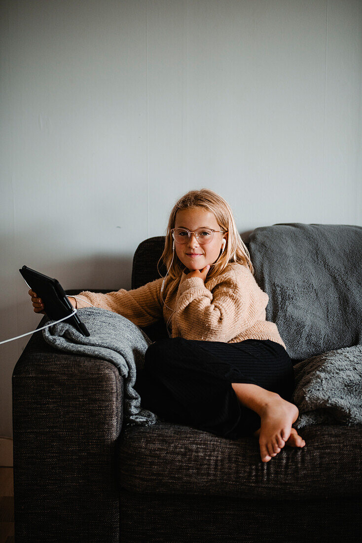 Girl on sofa using digital tablet