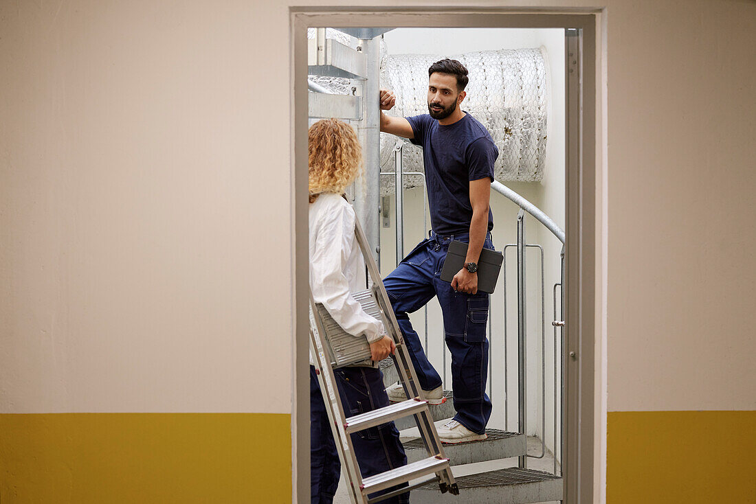 Man and woman checking air duct