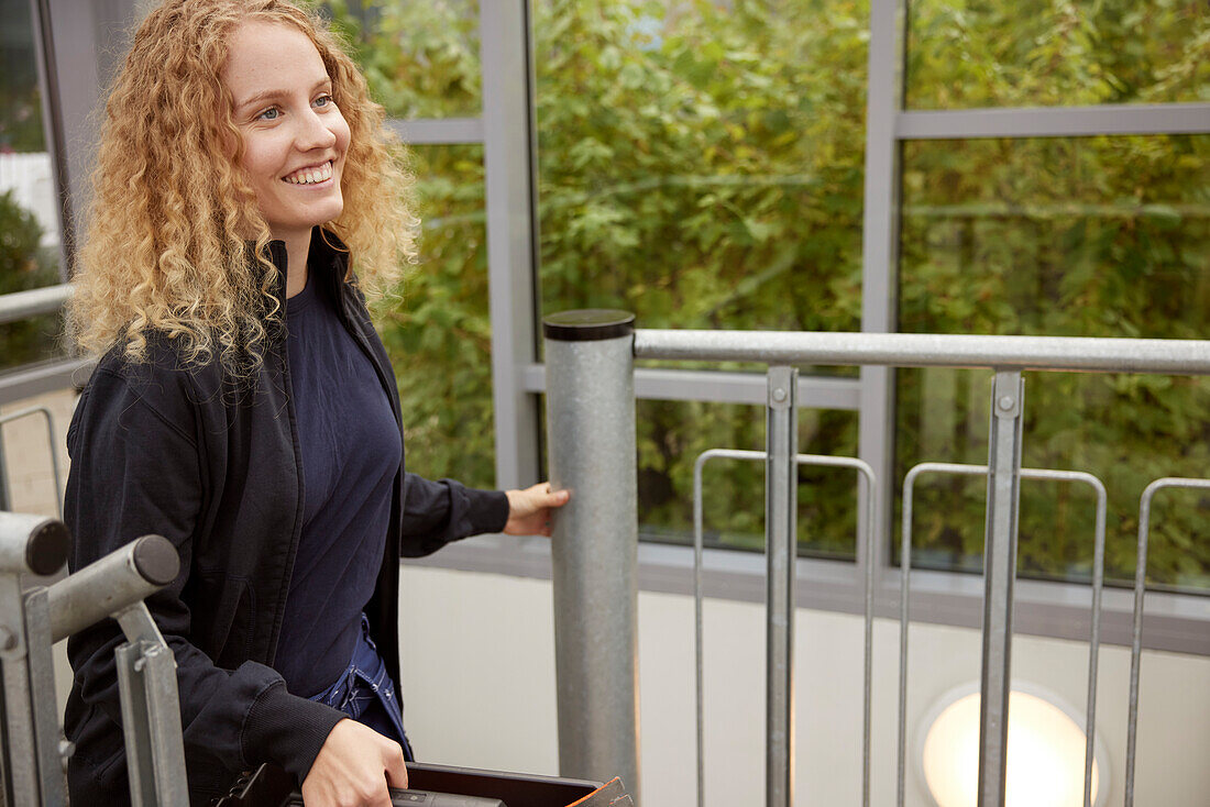 Smiling woman moving up stairs