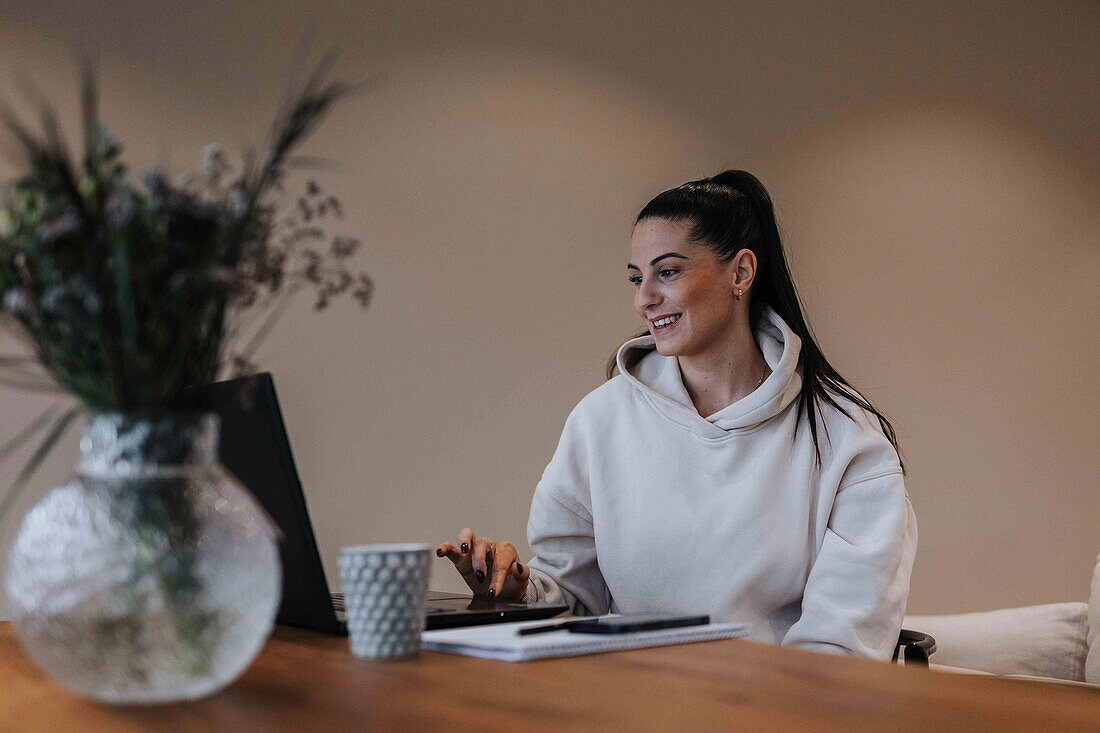 View of smiling woman using laptop