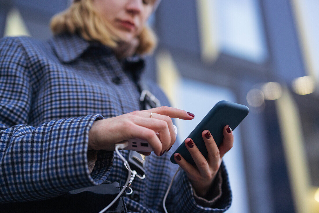 Junge Frau beim Telefonieren im Freien