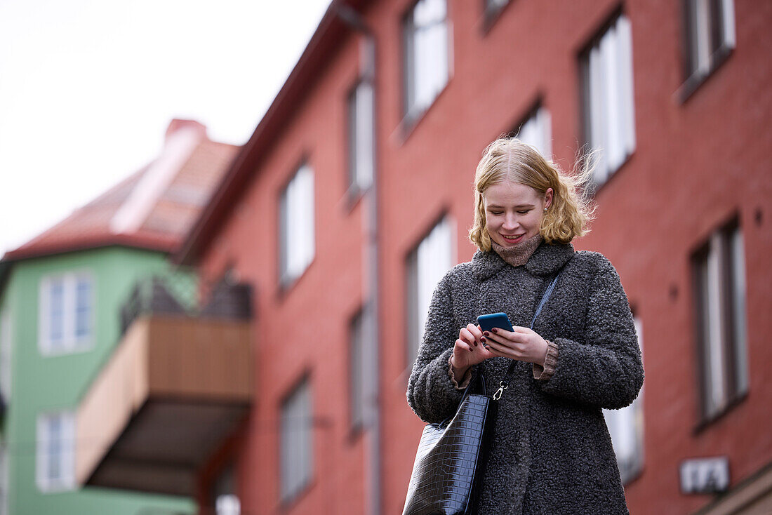 Smiling woman using cell phone