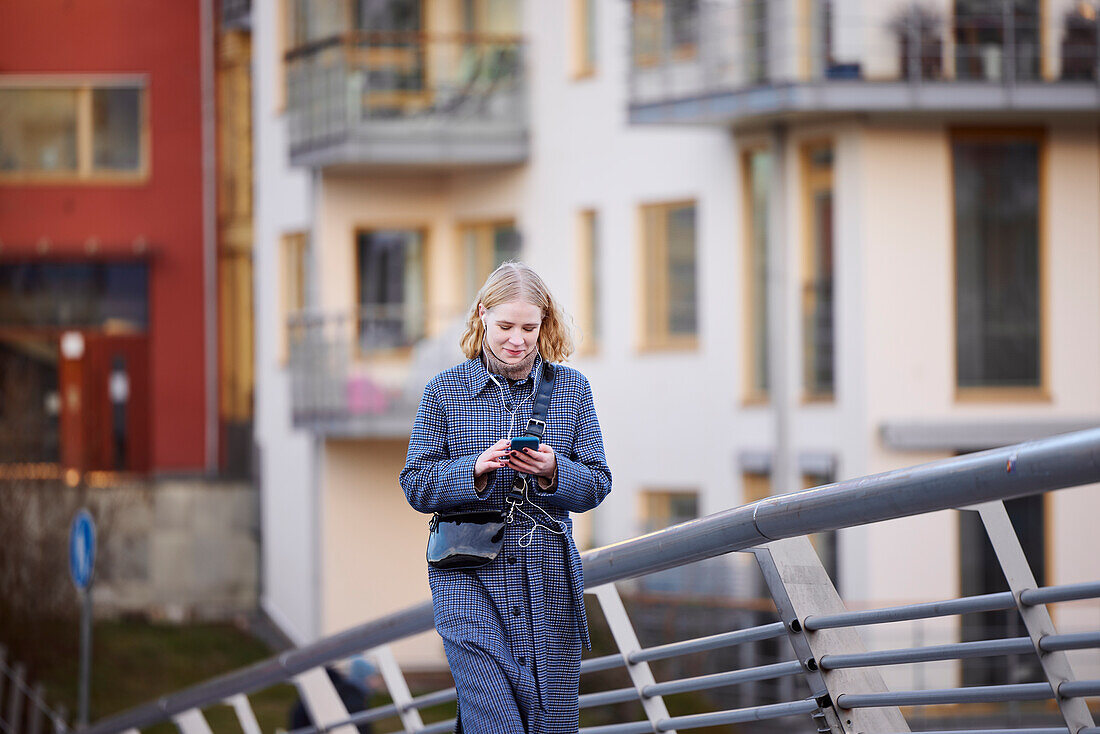 Frau beim Gehen, während sie ein Handy benutzt