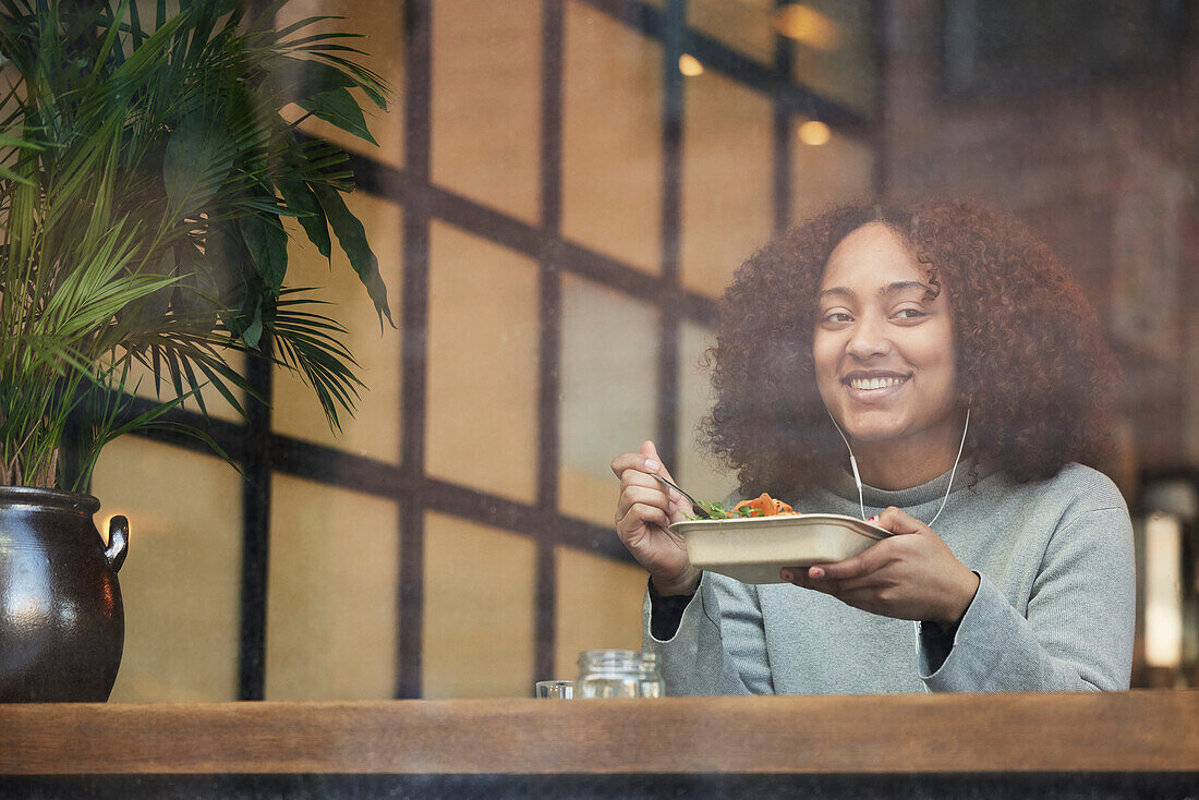 Young woman eating in cafe