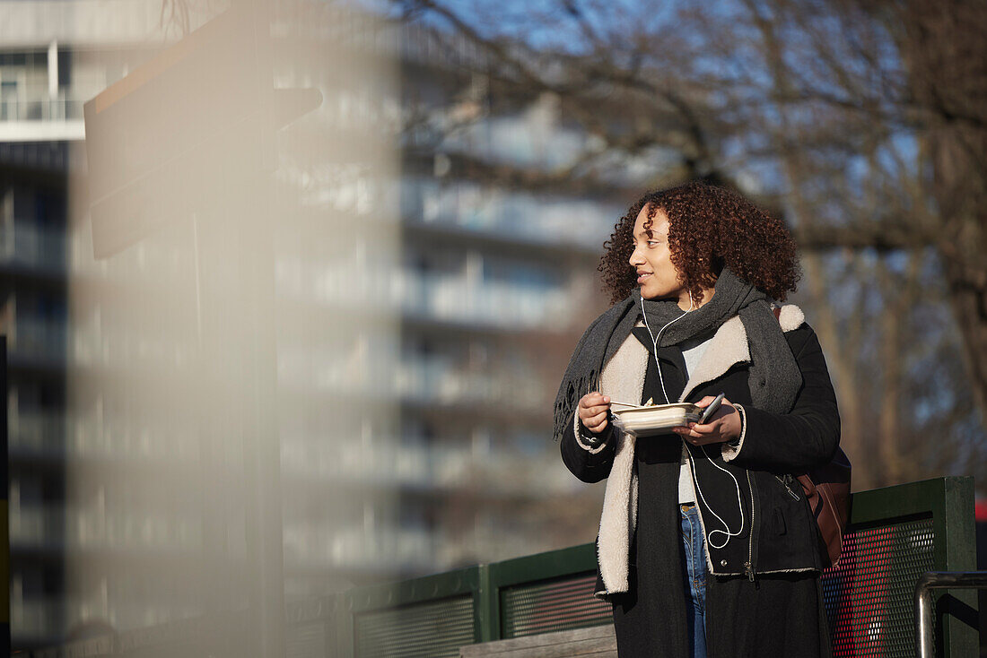 Woman eating at bus stop