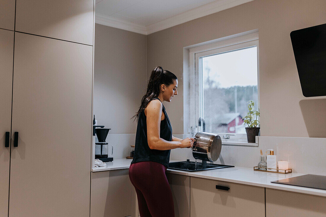 Woman washing dishes in kitchen