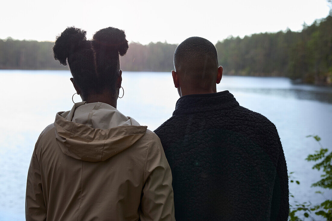 Rückansicht eines Mannes und einer Frau mit Blick auf einen See