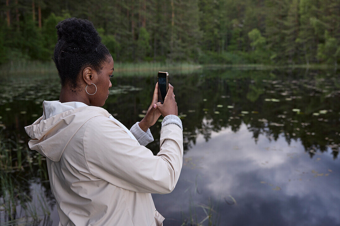 Young woman taking photo with cell phone