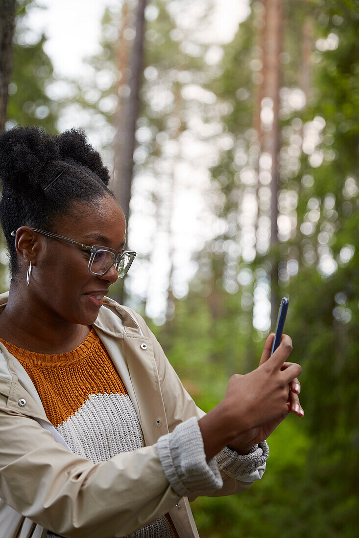 Young woman taking photo with cell phone