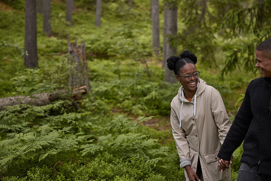 Smiling couple walking through forest