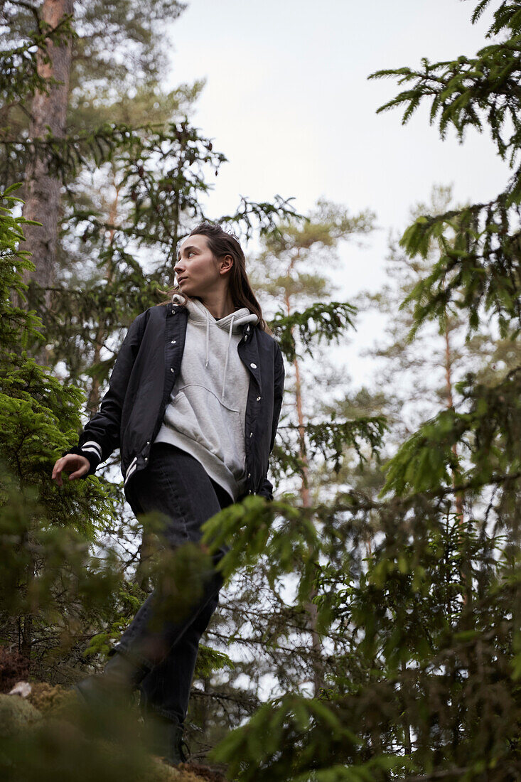 Low angle view of woman standing in forest