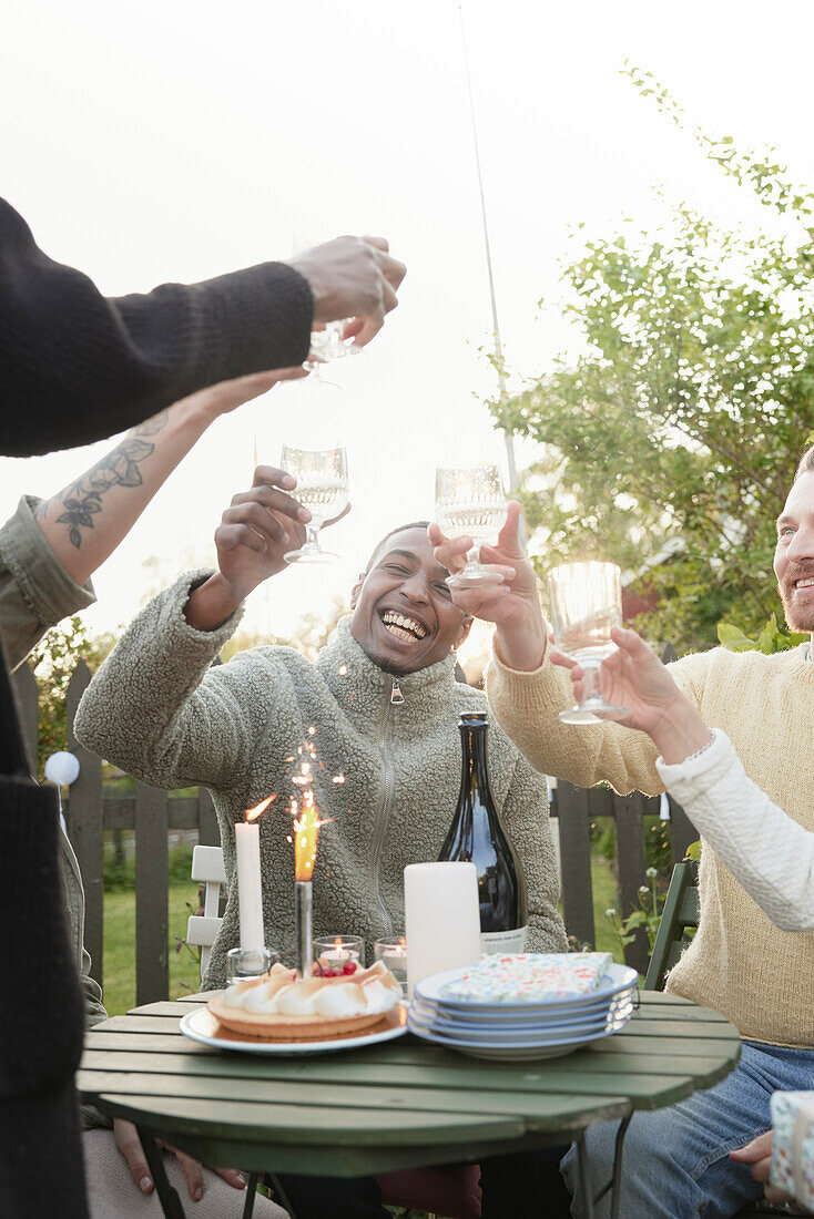 Fröhliche Freunde feiern eine Party im Garten