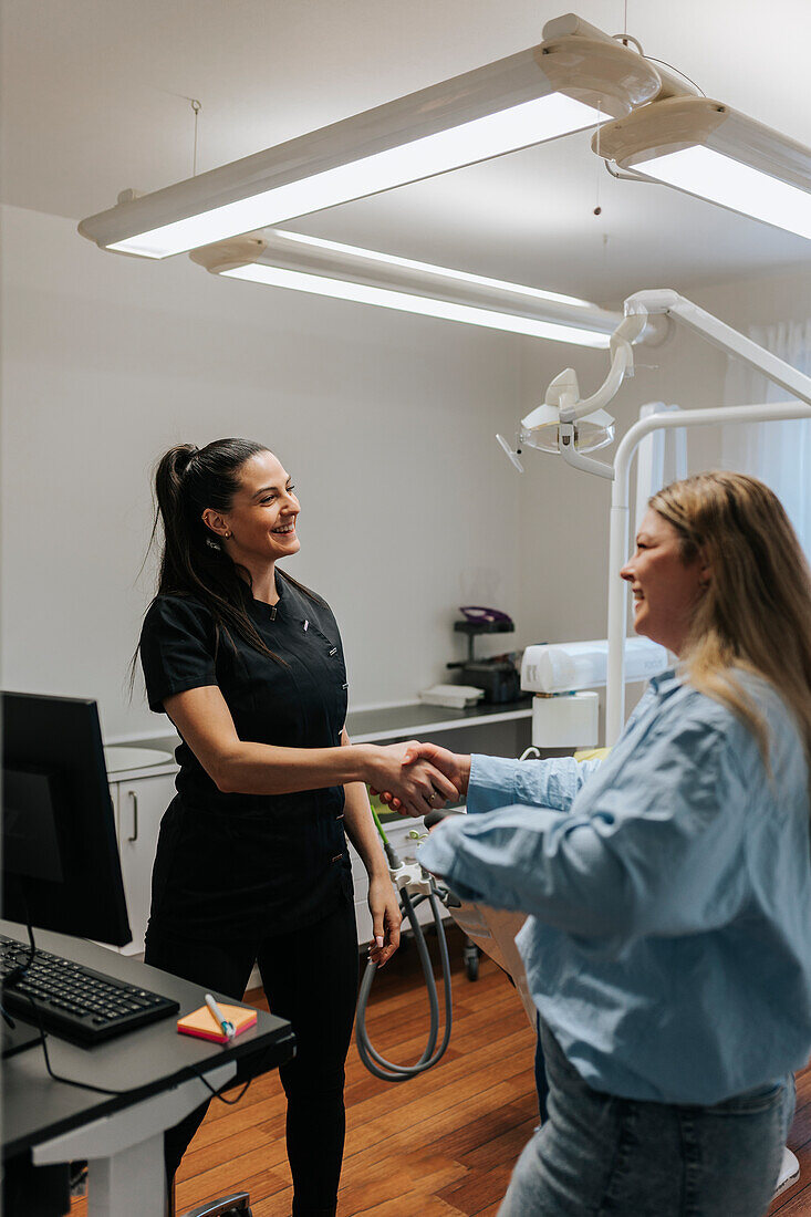 Zahnärztin begrüßt Patientin in der Praxis