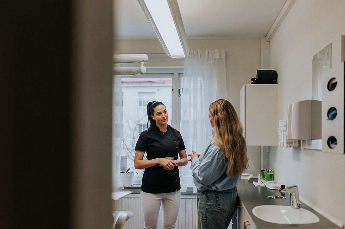 Female dentist talking with patient in dentist's office