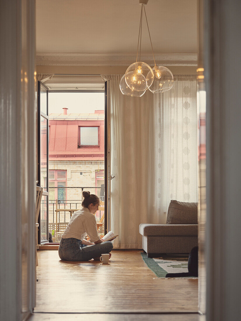 Frau liest ein Buch im Wohnzimmer