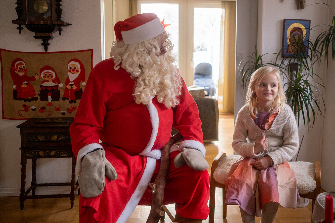 Girl with Santa Claus sitting in living room