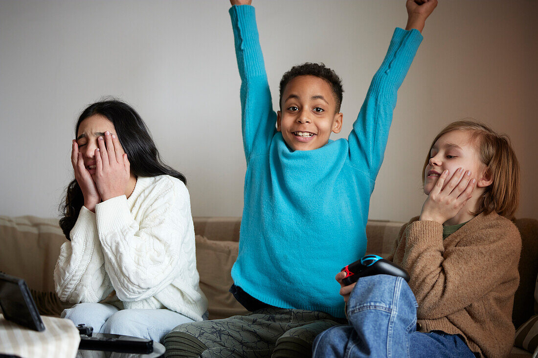 Children playing video games at home and celebrating