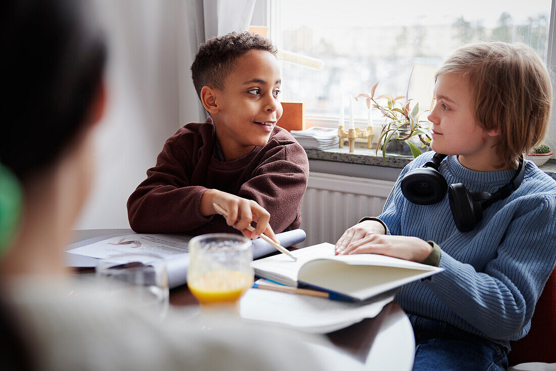 Zwei Jungen machen Hausaufgaben am Esstisch