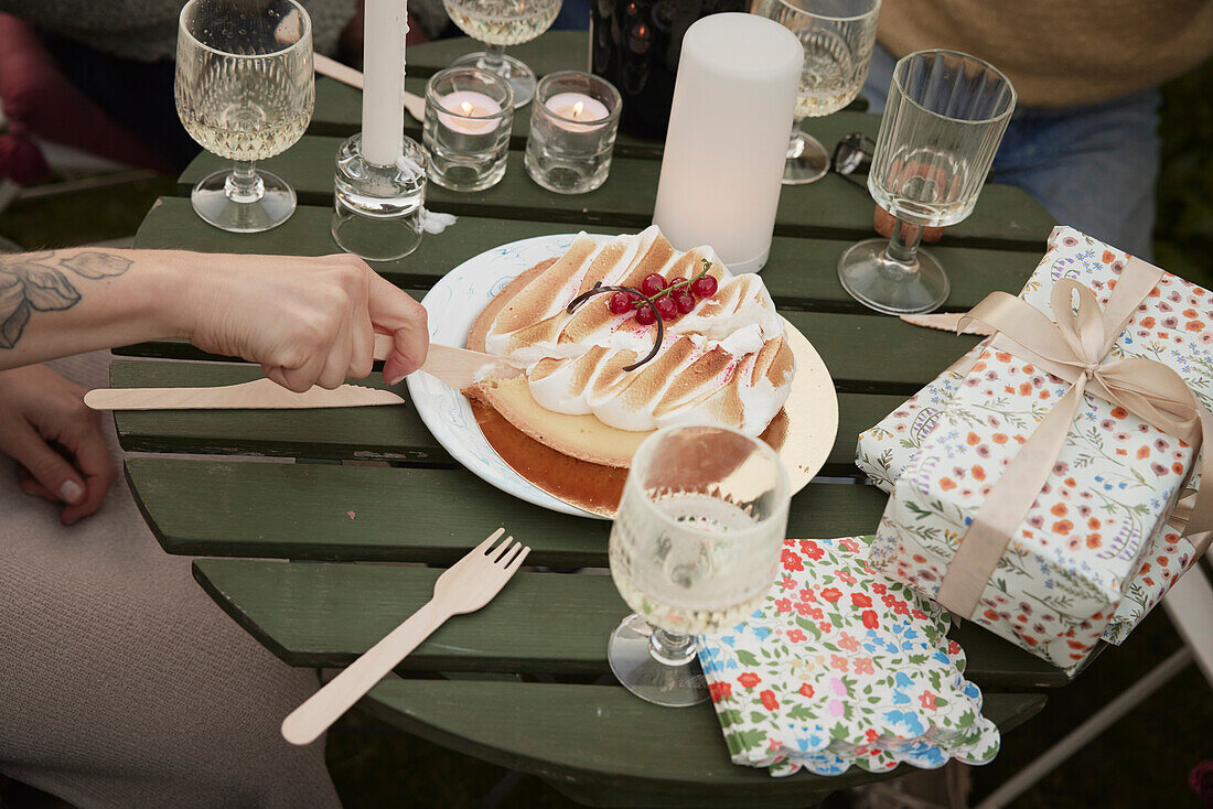 High angle view of hand cutting birthday cake