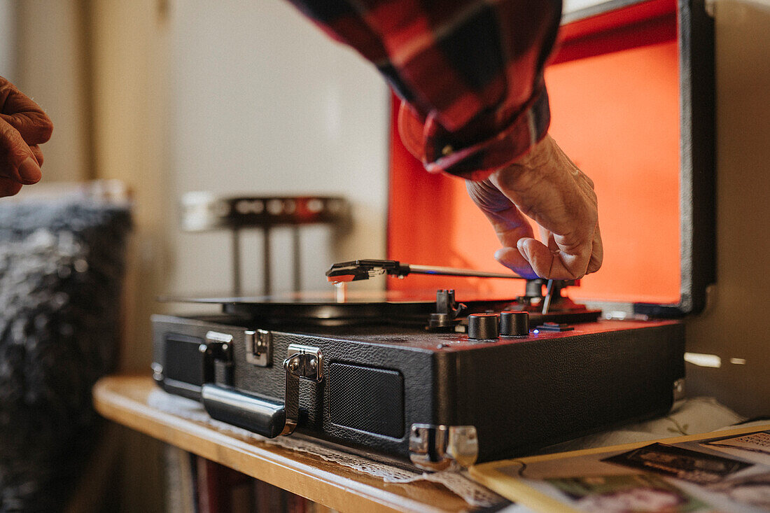 Älterer Mann benutzt zu Hause ein Grammophon