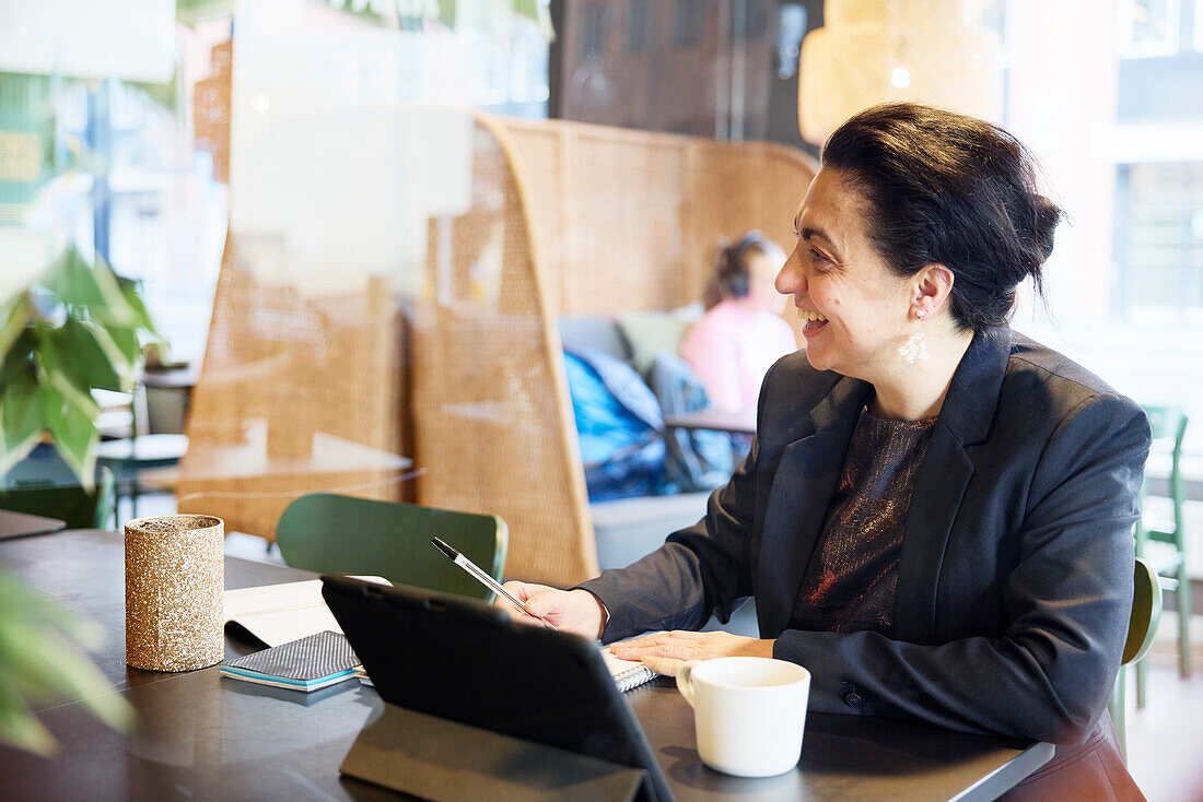 Smiling businesswoman sitting in cafe