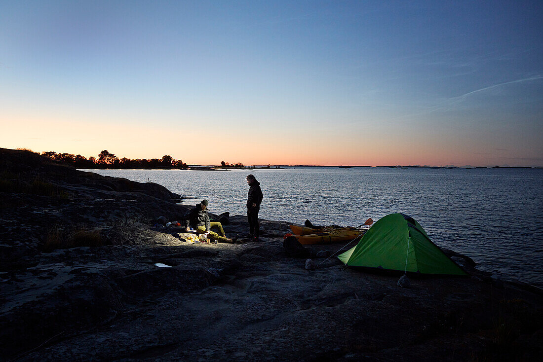 Blick auf die Touristen auf dem Campingplatz am Meer bei Sonnenuntergang