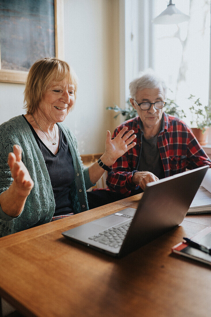 Senior couple using laptop at home