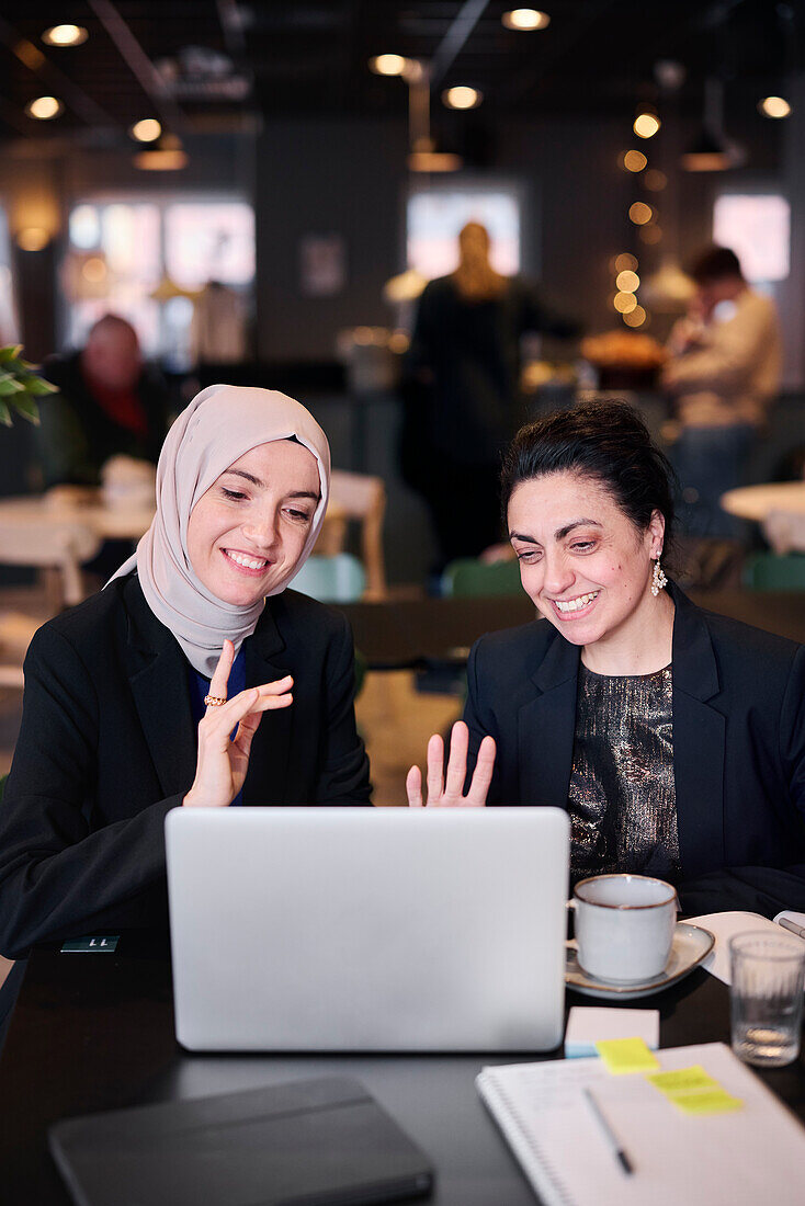 Businesswomen using laptop in cafe