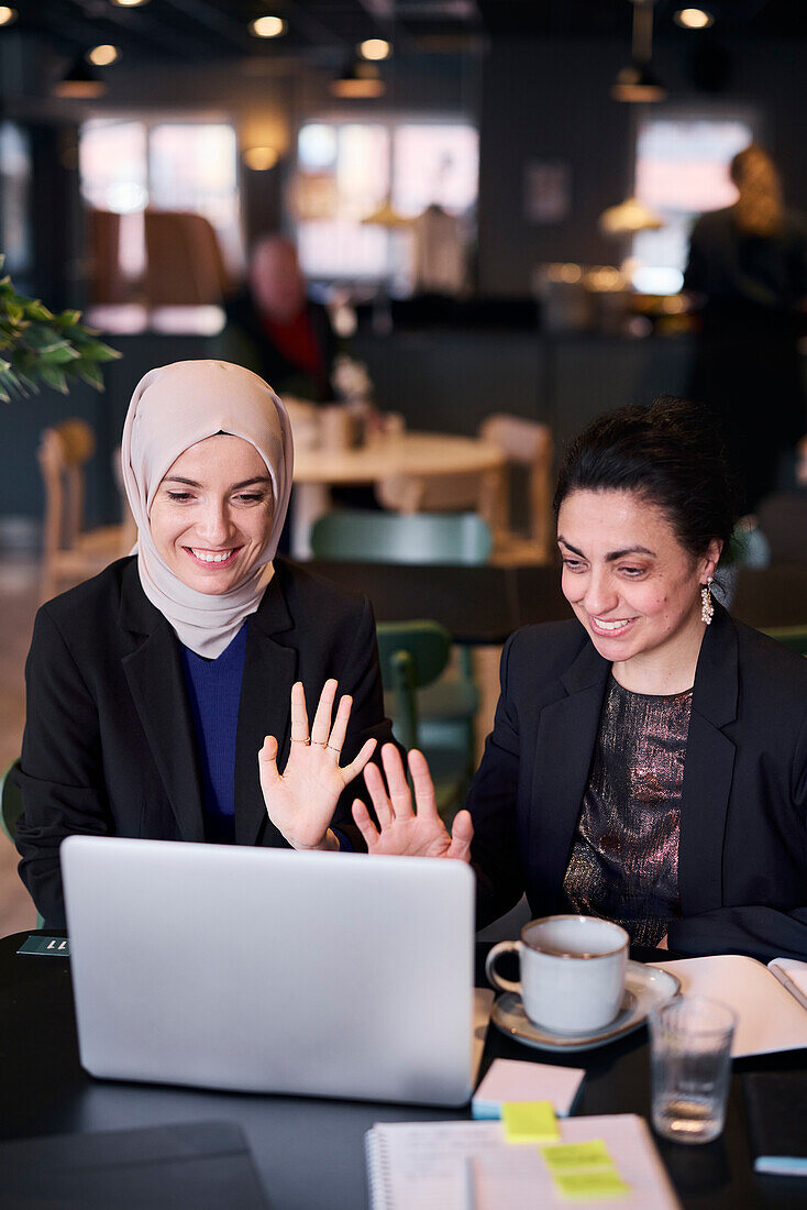 Businesswomen using laptop in cafe