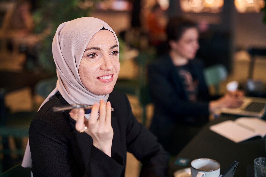 Businesswoman using cell phone in cafe