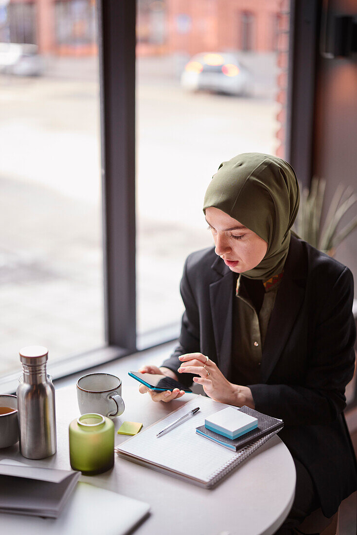 Frau mit Handy in einem Café