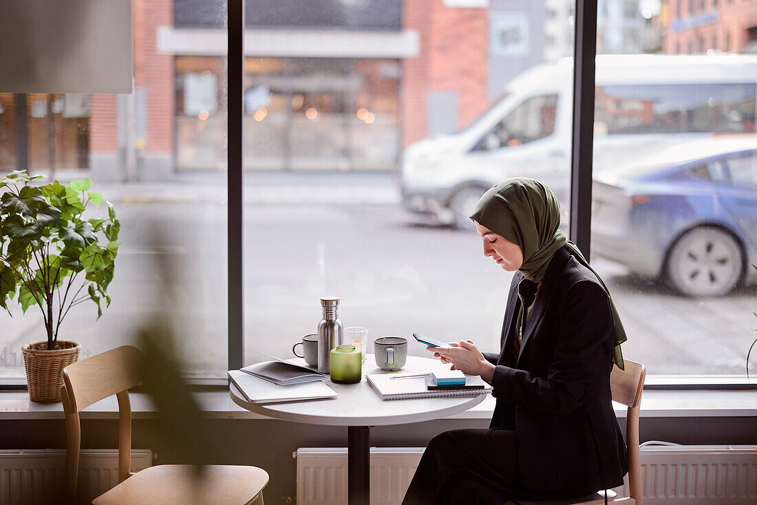 Frau mit Handy in einem Café