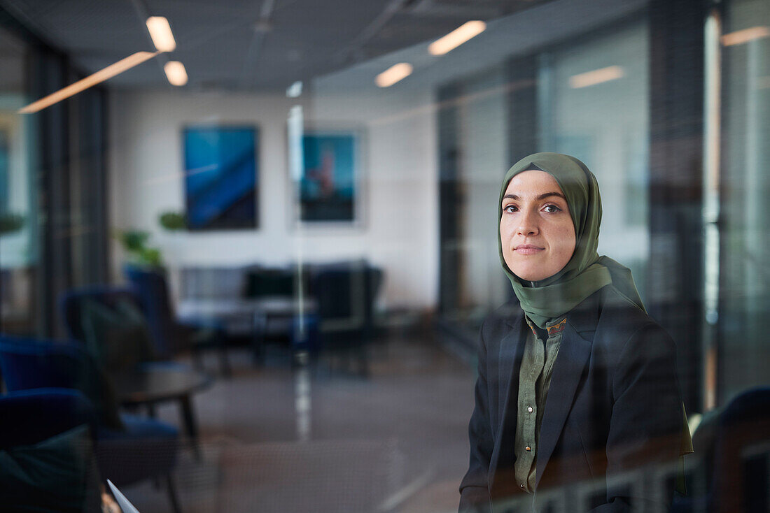 Woman in headscarf looking through window